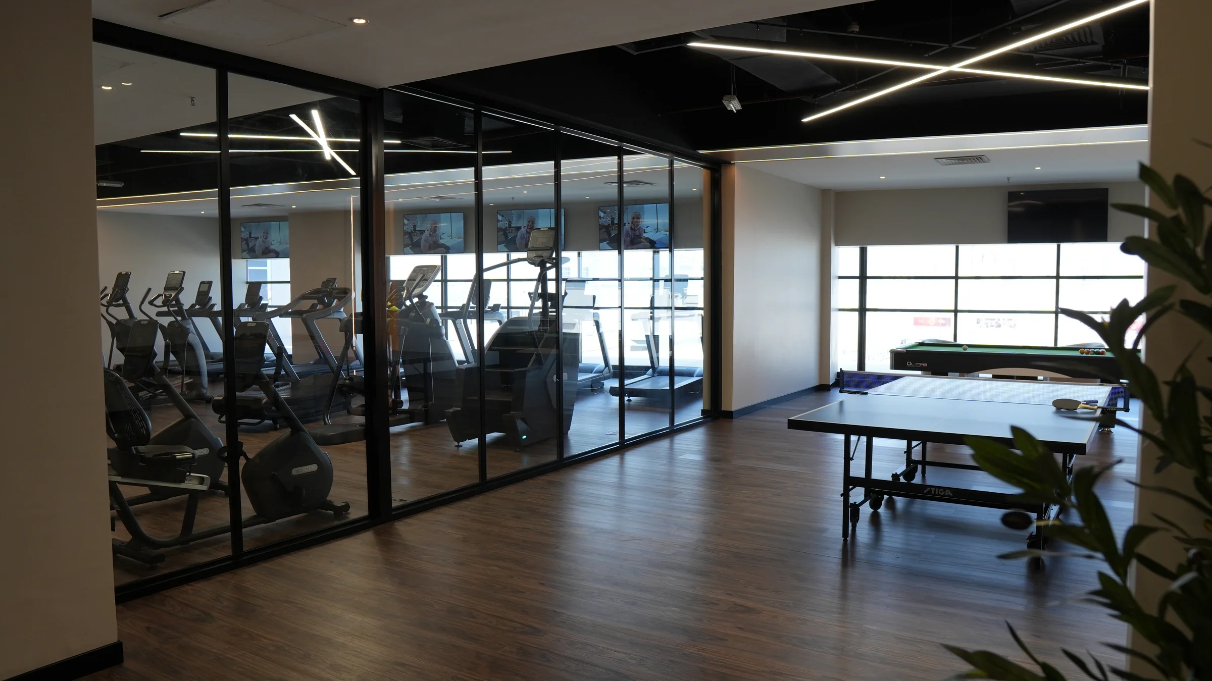The club lounge, with games and a view into the cardio area