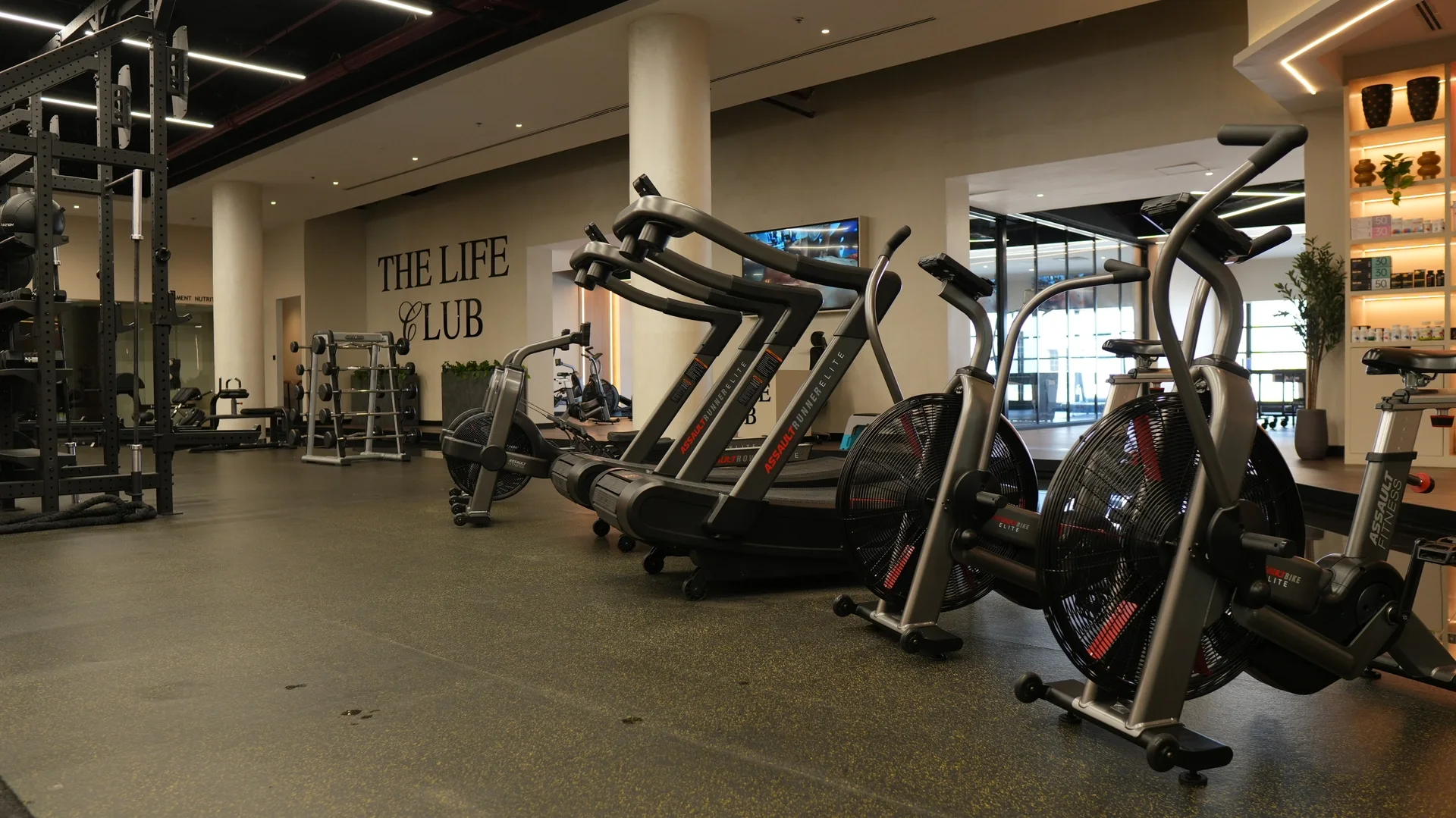 Air bikes and curved treadmills beside the main floor