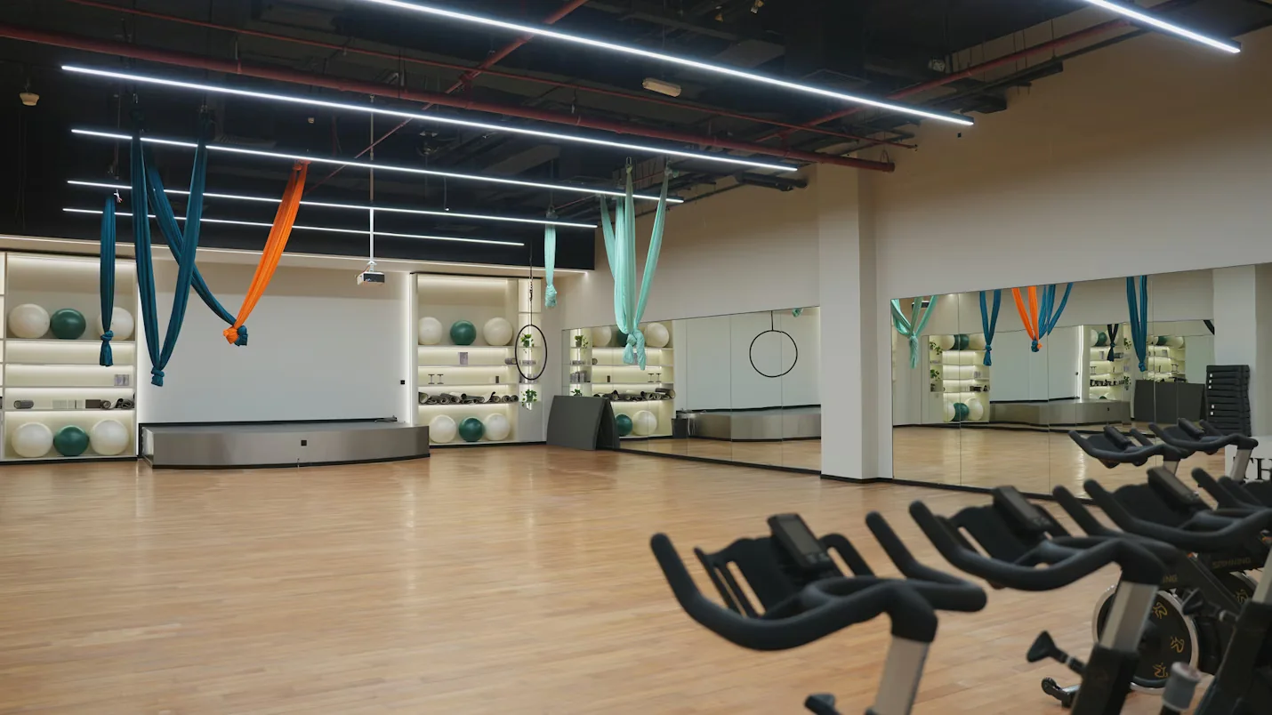 The mirrored class studio with aerial hammocks and exercise bikes